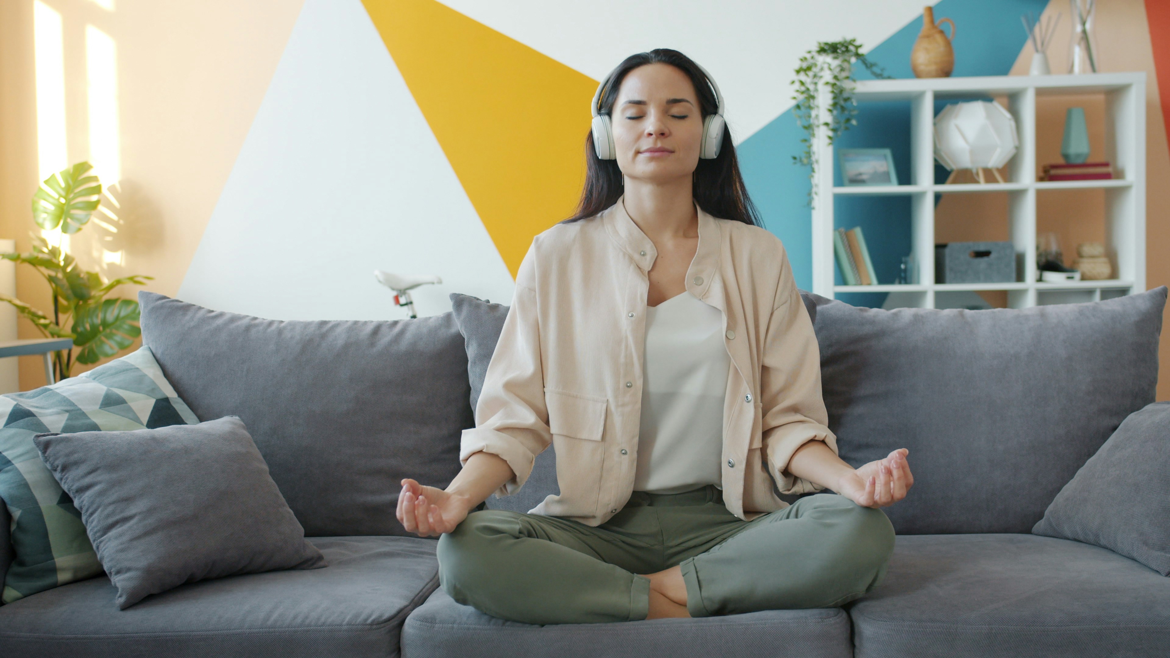 A person wearing headphones with eyes closed while listening
